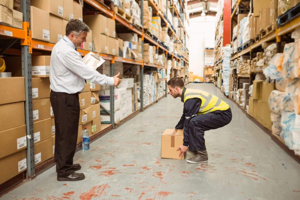 Employee at warehouse learns how to lift a box