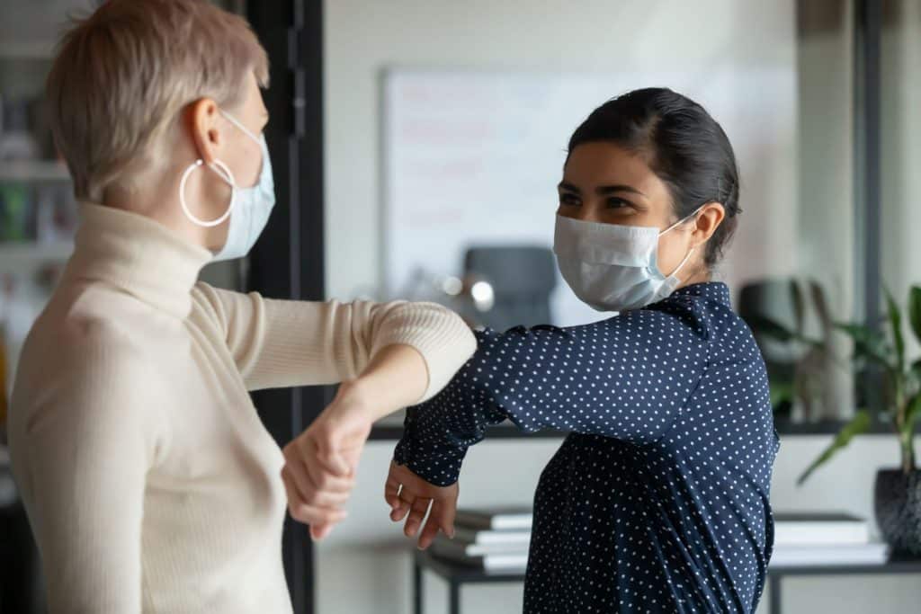 happy employees wearing face masks due to pandemic
