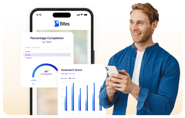 A person is smiling at a smartphone with a mobile app interface showing graphs and team assessment data on the screen.